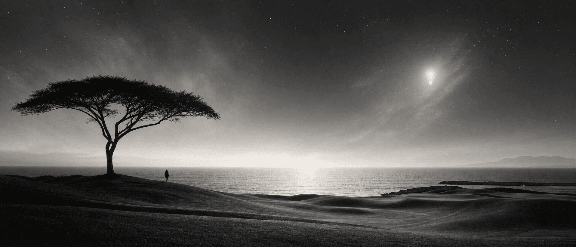 Black-and-white cinematic landscape with an acacia tree, ocean horizon, small human figure, and subtle glowing lightbulb in the sky.